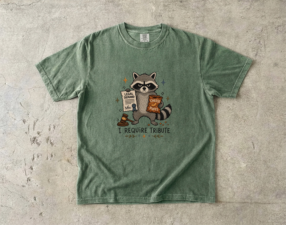 Green t-shirt with raccoon holding a legal demand and cheese puffs.