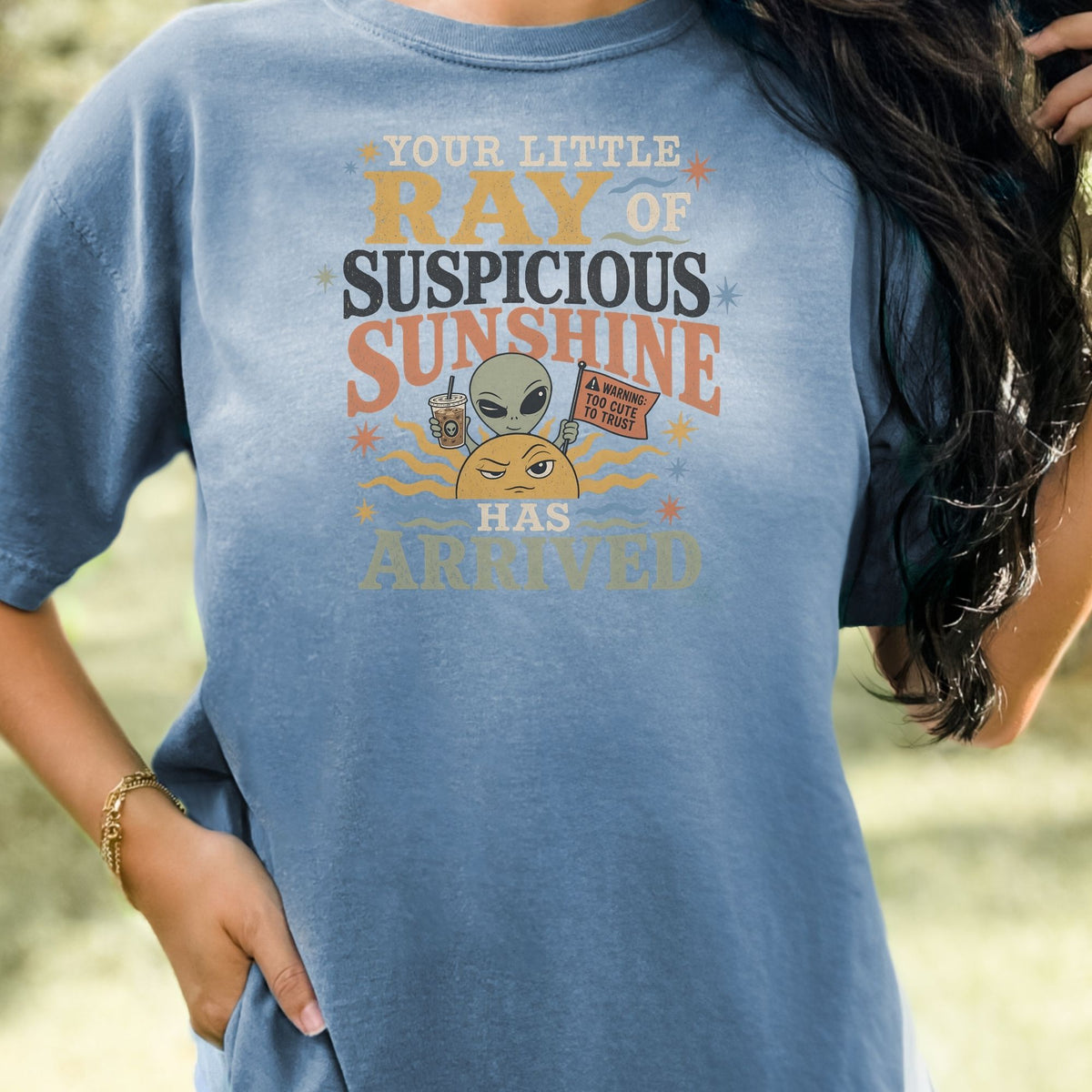T-shirt graphic: Your little ray of suspicious sunshine has arrived with alien and sun.