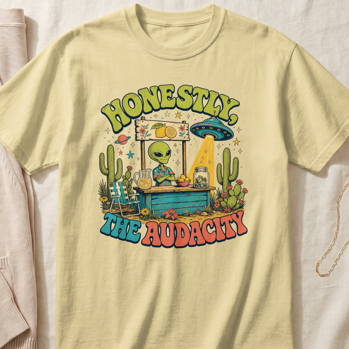 Alien at a stand selling lemonade, with a UFO above. Text reads "HONESTLY, THE AUDACITY."