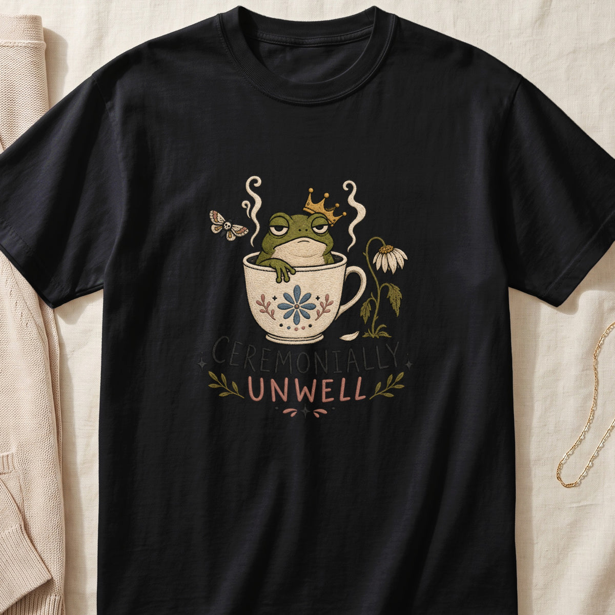 Black t-shirt with a frog wearing a crown in a teacup and "CEREMONIALLLY UNWELL" text.