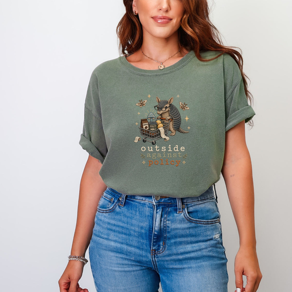 Green t-shirt with armadillo in shopping cart graphic, text "outside against policy".