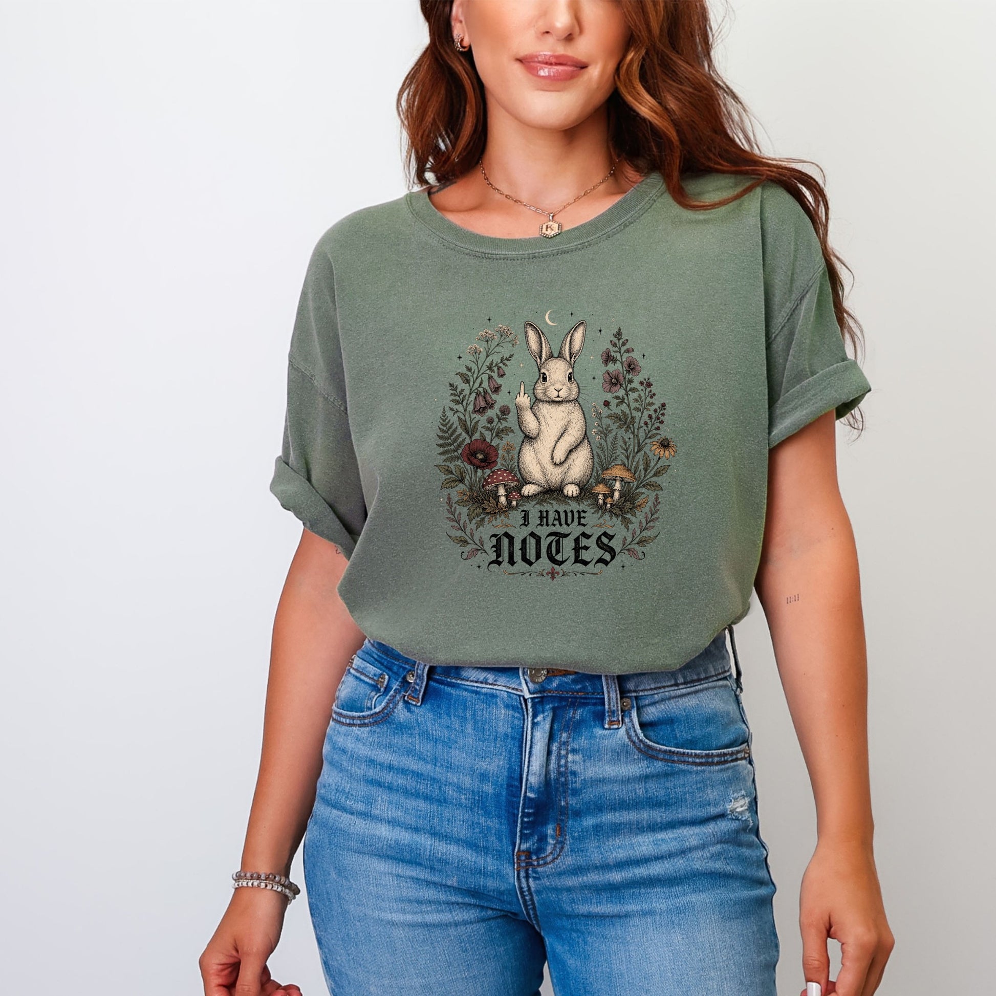 Green t-shirt with a rabbit and mushrooms graphic reading "I HAVE NOTES."