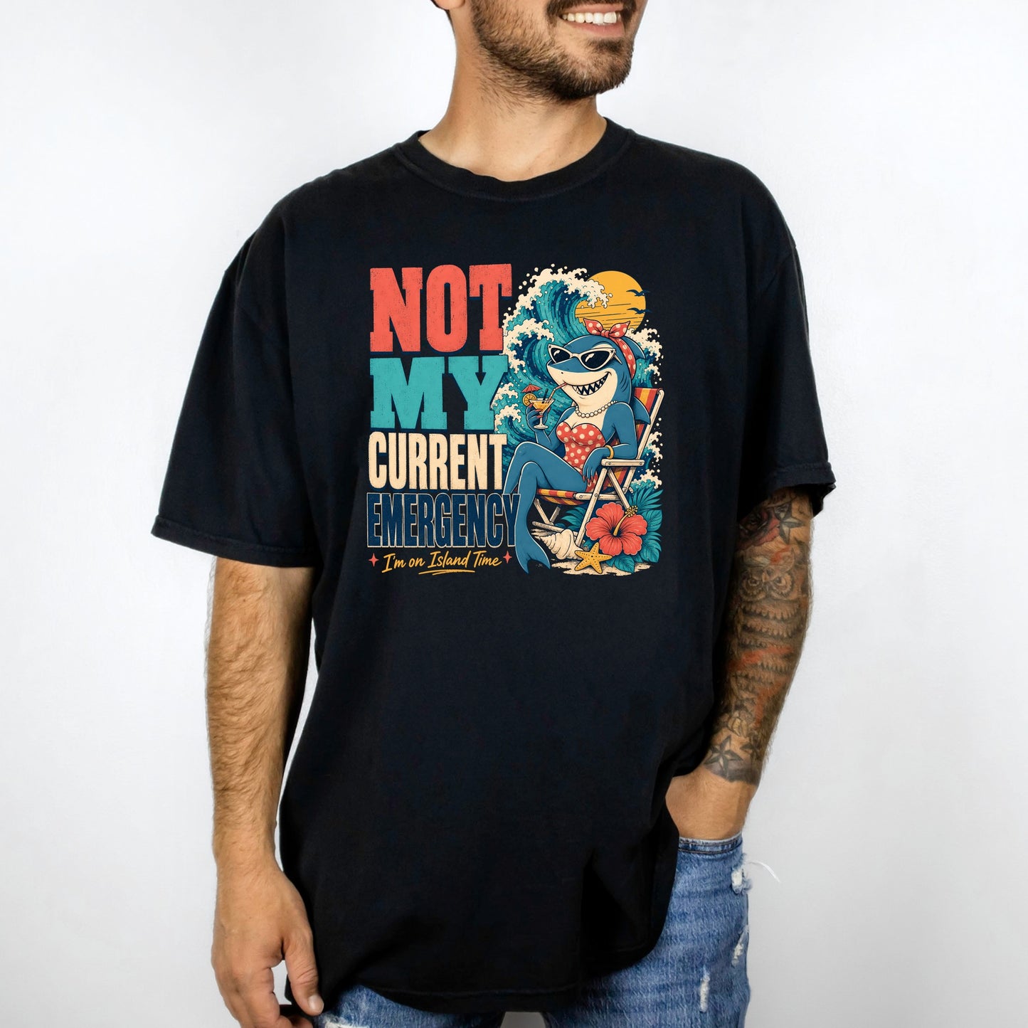 Black t-shirt with graphic: "NOT MY CURRENT EMERGENCY" and shark on island time.
