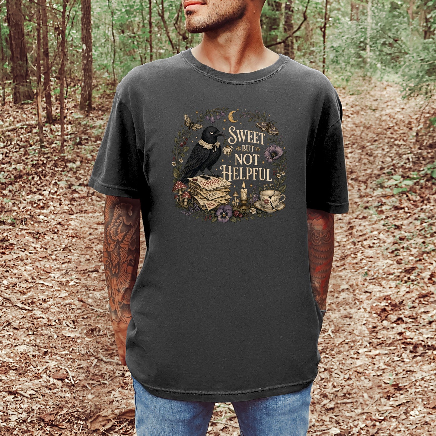 Dark grey t-shirt with crow, books, and teacup design reading "Sweet but Not Helpful".