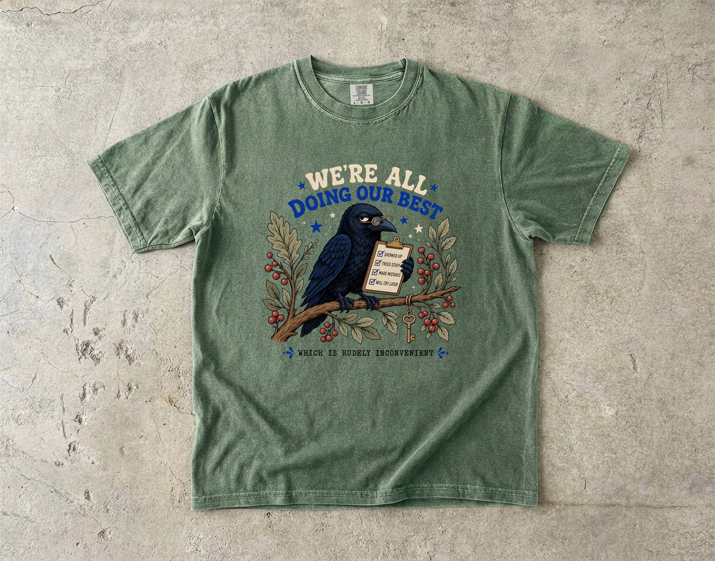 Green t-shirt with raven holding clipboard reading "We're all doing our best."