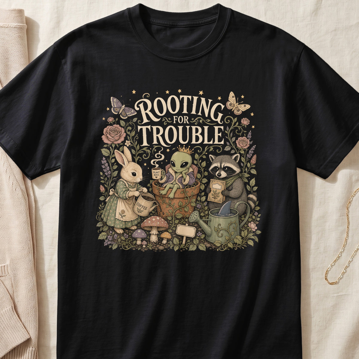 T-shirt with "ROOTING FOR TROUBLE" text featuring rabbit, alien, and raccoon characters.