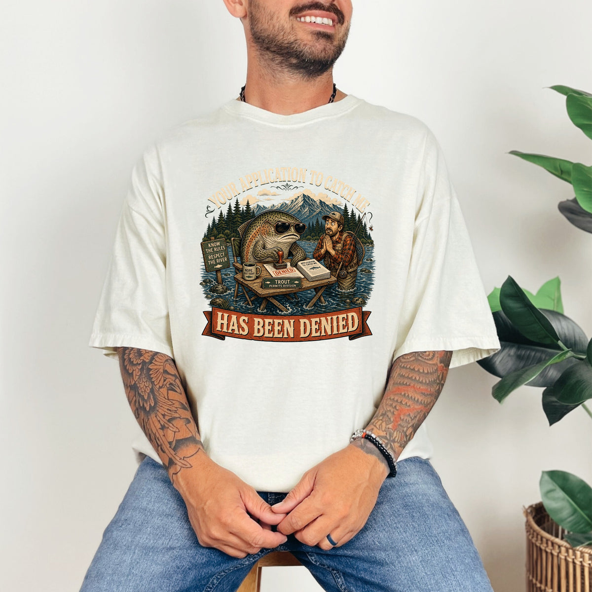 T-shirt graphic of a fish denying a fisherman's application with text "Has Been Denied".